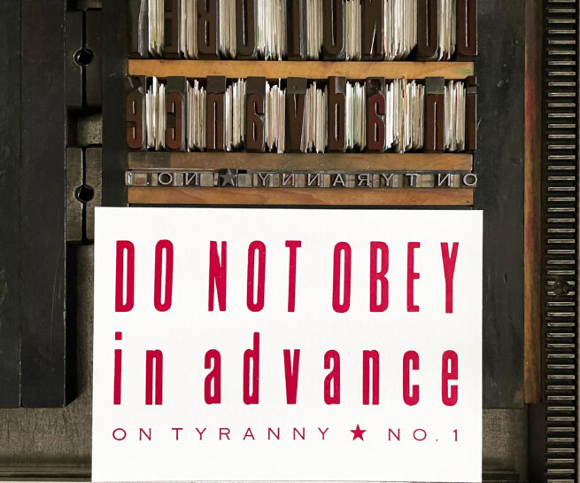 Image of printed letterpress print on Vandercook press bed. Printed in red ink, the print reads "Do Not Obey in Advance On Tyranny No. 1"