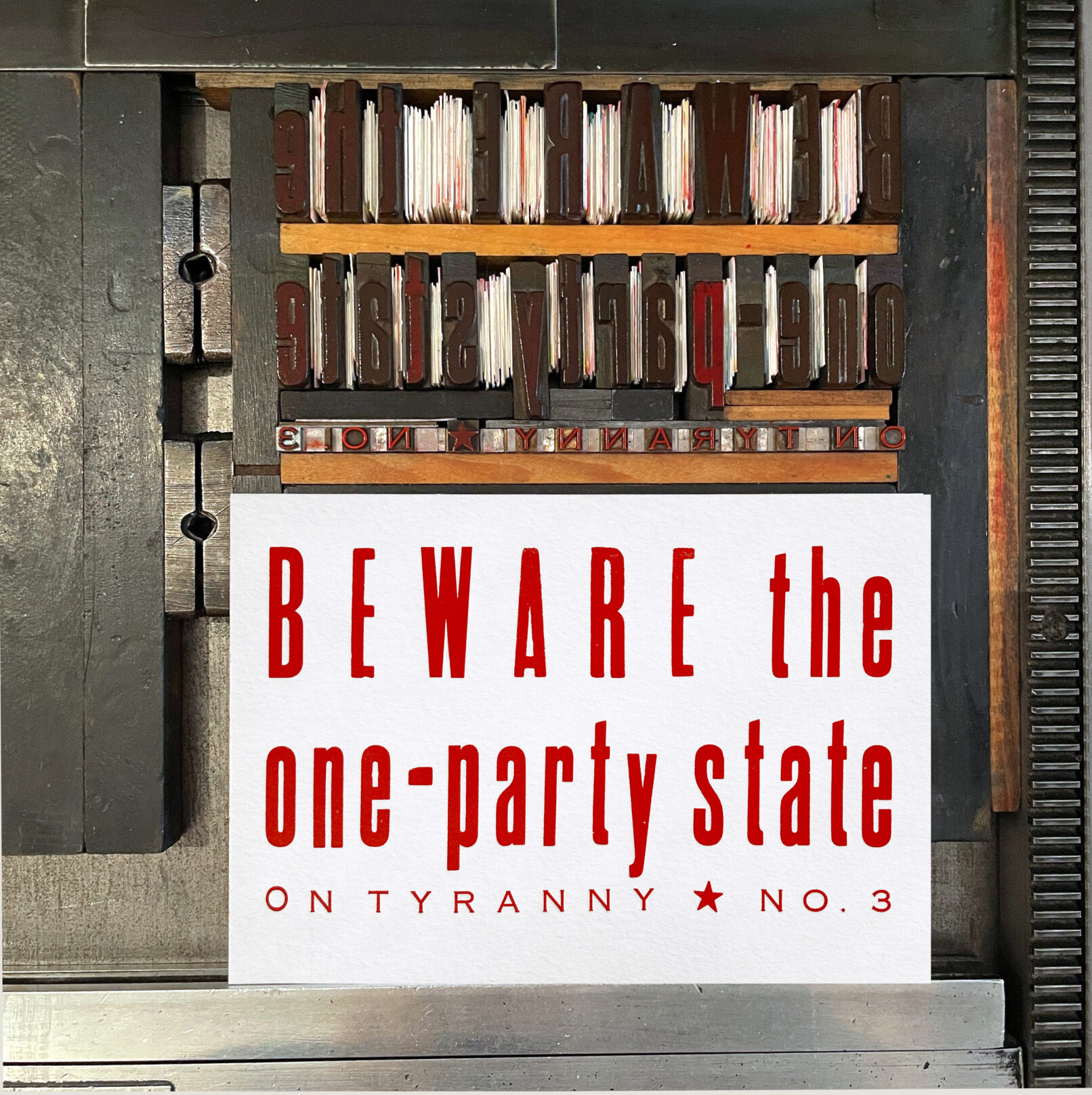 Letterpress print on Vandercook press bed. Printed in red ink on white paper, the text reads "Beware the One Party State On Tyranny No. 3."
