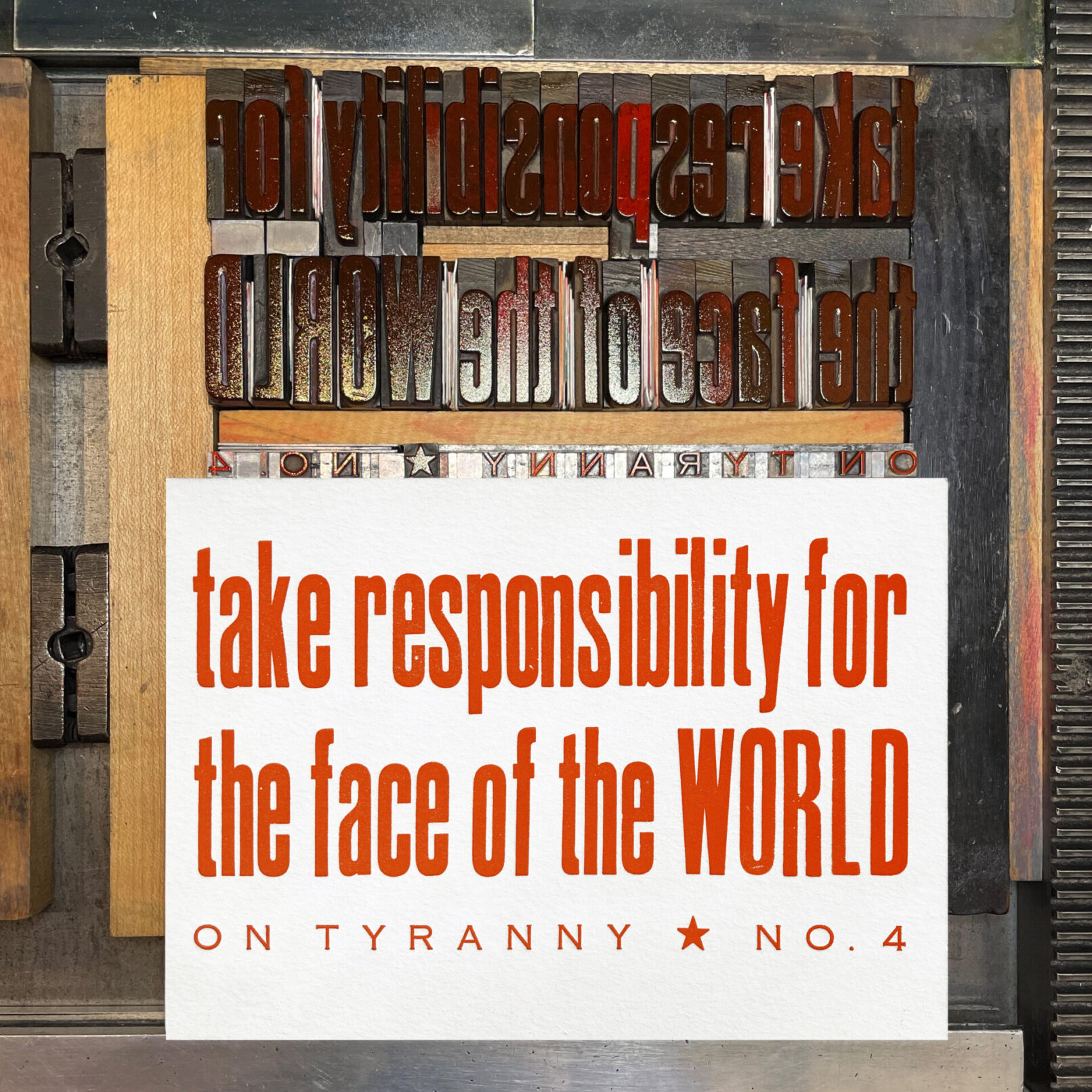 Letterpress print on Vandercook press bed. Printed in reddish orange ink on white paper, the text reads "Take Responsibility For The Face of the World On Tyranny No. 4."