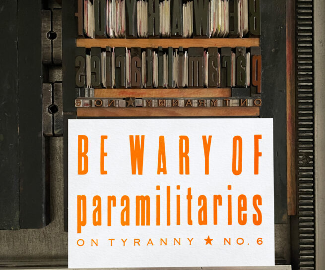 Letterpress print on Vandercook press bed. Printed in orange ink on white paper, the text reads "Be Wary of Paramilitaries On Tyranny No. 6."